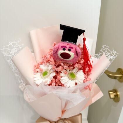 Graduation bouquet with plush toy bear, fresh flowers, and preserved blooms, styled in pastel wrapping — popular in Singapore.